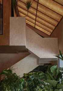 A daytime photo of a simple staircase with concrete steps, set against a neutral background, with natural light illuminating the scene