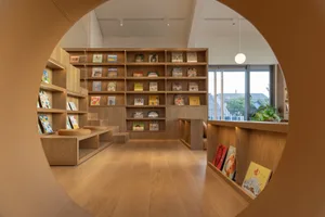 A cozy library with wooden bookshelves, a warm atmosphere, and a wide selection of books on display