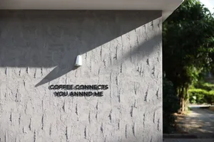 Exterior wall with a concrete surface and a sign reading Coffee Connects You