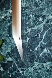 A marble wall with a modern metal sculpture attached, showcasing a minimalist design with contrasting materials and textures