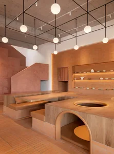 Warm and inviting restaurant interior with wooden tables and chairs, multiple dining areas with various seating arrangements