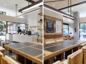 Warm and inviting restaurant interior with wooden elements, tables, chairs, and kitchen appliances