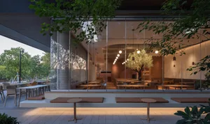 Bright and welcoming restaurant interior with large windows, dining tables, and chairs, featuring umbrellas for shade and comfort