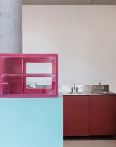 Modern bathroom with a pink cabinet, sink, and mirror, featuring clean lines and minimalistic elements