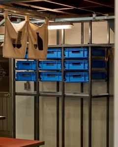 Industrial storage space with blue plastic bins and storage containers in a warehouse environment