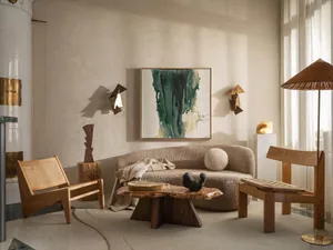 A modern living room with a couch, coffee table, chairs, paintings, and well-lit atmosphere