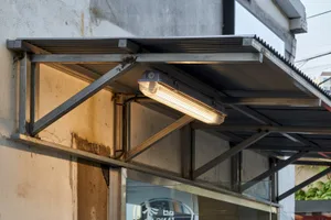 建築物底部有金屬屋頂，車輛停放其下，展現其設計元素與結構