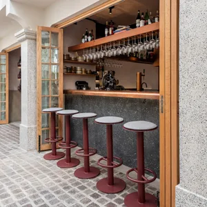 A cozy bar area with a counter, sink, and wine rack, featuring wine glasses and bottles, creating a warm and inviting atmosphere for patrons