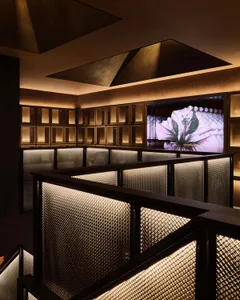 A modern gallery space with multiple screens and a warm atmosphere, featuring wooden walls and a contemporary design