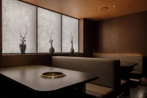 A modern restaurant with a brown color scheme, featuring multiple dining tables and chairs, creating a warm and inviting atmosphere