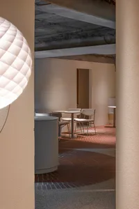 A cozy dining area with several chairs and small tables, featuring a modern and minimalist design