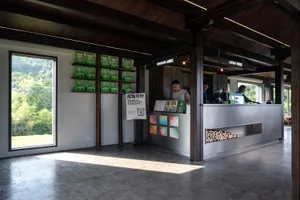 Casual restaurant interior with a dining table, chairs, counter, and bottles, set in a warm and inviting atmosphere
