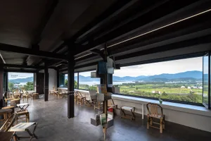 溫馨客廳空間，木質地板與牆面、大片窗戶，眺望周圍山景