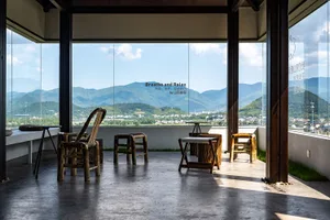 Cozy mountain retreat with natural stone walls, wooden furniture, and a large window overlooking the surrounding mountains