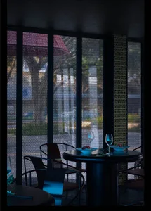 A formal dining area with a round table and chairs, set with wine glasses, in a restaurant-like atmosphere