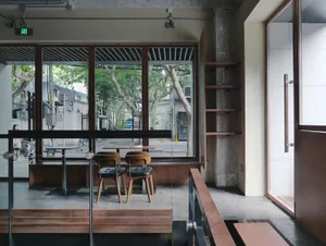Modern restaurant interior with wooden floors and walls, comfortable seating areas, and ample space for guests