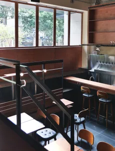 A warm and inviting restaurant interior with wooden floors and tables, comfortable seating, and ample space for guests