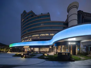 藍色強調的現代建築，內部燈光照亮窗戶，營造夜晚生動氛圍