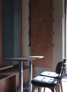 Dining room with a wooden table and leather chairs, surrounded by a warm wooden wall, creating a cozy atmosphere for meals and gatherings
