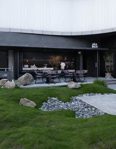 A dining table surrounded by chairs in an inviting outdoor restaurant area with a building in the background