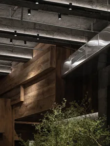 Modern interior space with wooden walls and ceiling, featuring two large windows and a clean, minimalistic design