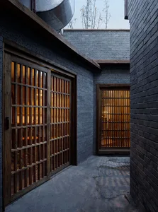 Dark and mysterious Asian-style house with a black brick exterior and limited natural light