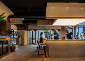 Inviting restaurant interior with a counter, dining table, chairs, and potted plants