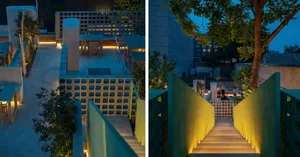 Modern restaurant with yellow railing, stairs, chairs, and dining tables