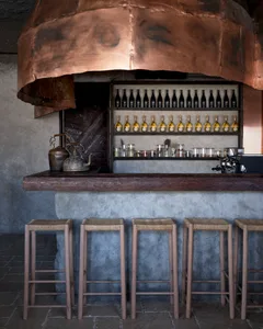 A warm and inviting bar area with a wooden countertop, copper ceiling, and comfortable seating for patrons