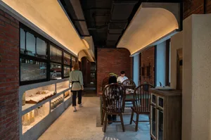 Cozy cafe interior with multiple wooden chairs and tables, creating a warm atmosphere for social gatherings