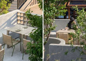 Outdoor dining area with wooden furniture, wine glasses, and bottles, set up for a casual meal or gathering
