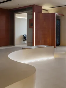 Modern bathroom with two toilets and two sinks on a white tiled floor, emphasizing cleanliness and organization