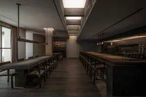 Empty restaurant with wooden floors and tables, chairs placed around the dining area, calm and inviting atmosphere