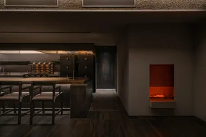 Industrial kitchen with a focus on the countertop and oven, surrounded by chairs and a dining table