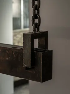Exposed metal structure with a chain hanging from the ceiling, featuring a mix of industrial and antique elements