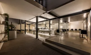 A lively modern restaurant interior with a large dining area, brick and concrete flooring, and multiple tables and chairs