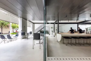 Bright and inviting restaurant with white walls, potted plants, and natural light from windows or glass partitions