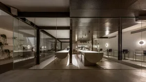 Industrial kitchen with white countertops, multiple dining tables, and various appliances, set in a clean and organized space