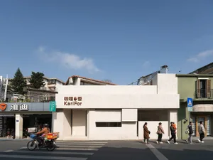 繁忙的城市街景，白色建築、行人，以及騎腳踏車的人