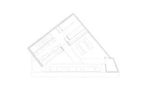 A spacious office interior with multiple rooms and hallways, well-lit by natural sunlight through skylights