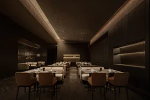 Elegant restaurant interior with wooden floors, white tablecloths, and comfortable seating areas