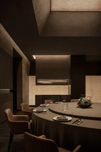 A modern dining area with a round table, dark wood elements, and warm brown and white tones, creating a cozy atmosphere