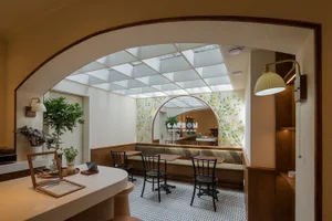 A well-lit restaurant dining area with wooden chairs and tables, creating a cozy atmosphere for guests to enjoy their meals