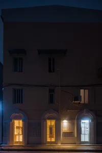 兩棟三層樓現代建築，配有窗戶與乾淨線條，位於街頭，營造寧靜而吸引人的氛圍