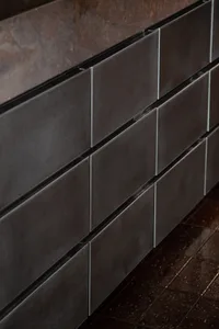 A modern kitchen cabinet with black metal doors and a sleek design, made of stainless steel, with a clean and organized appearance