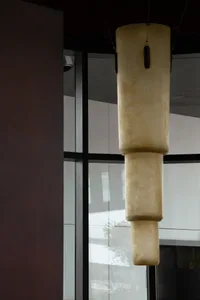 現代室內空間，設有大型白色混凝土雕塑、自然光線與盆栽植物