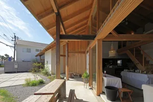 Open plan living and dining space with wooden beams, a bench, and chairs, giving a warm and inviting atmosphere