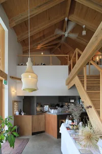 A modern kitchen with wooden floors, white walls, and various appliances, with a clean and organized atmosphere and focus on functionality