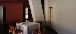 A cozy dining area with two tables and chairs, surrounded by warm lighting and inviting ambiance