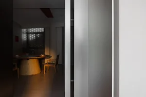 燈光柔和的餐廳，配有木桌木椅，紅色強調牆面營造溫馨氛圍
